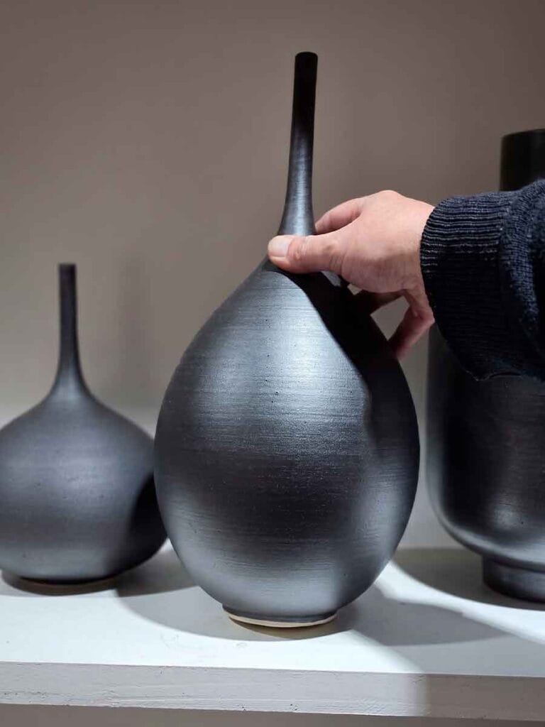 Hands touching finished stoneware ceramic surface — mineral slip texture, Fernando Durao Buenos Aires studio